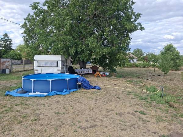 #12434 Eladó összközműves saroktelek Tóalmáson – modern lakókocsival együtt!